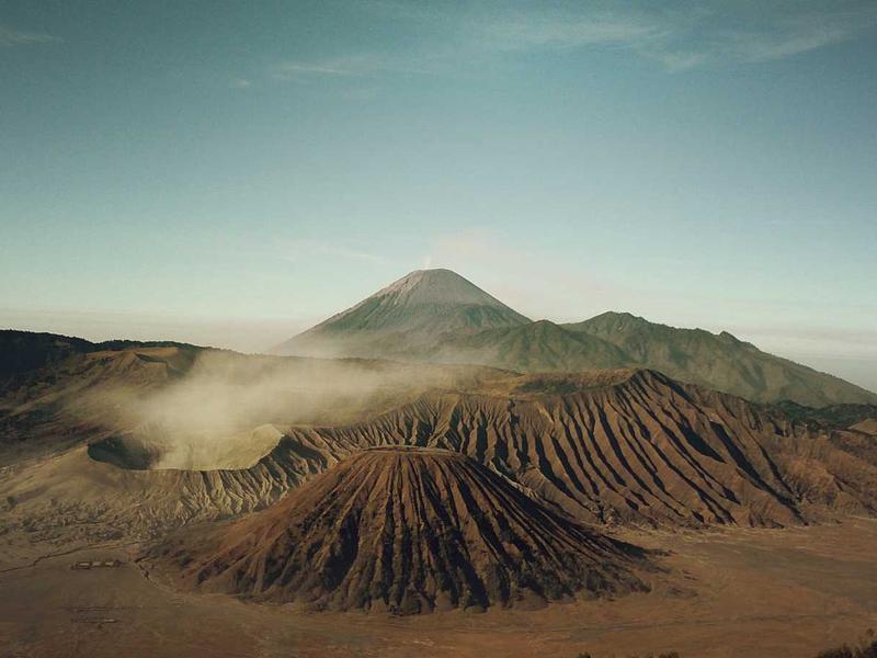 Sharp sunlit ridgeline of an orange desert dune against shadow